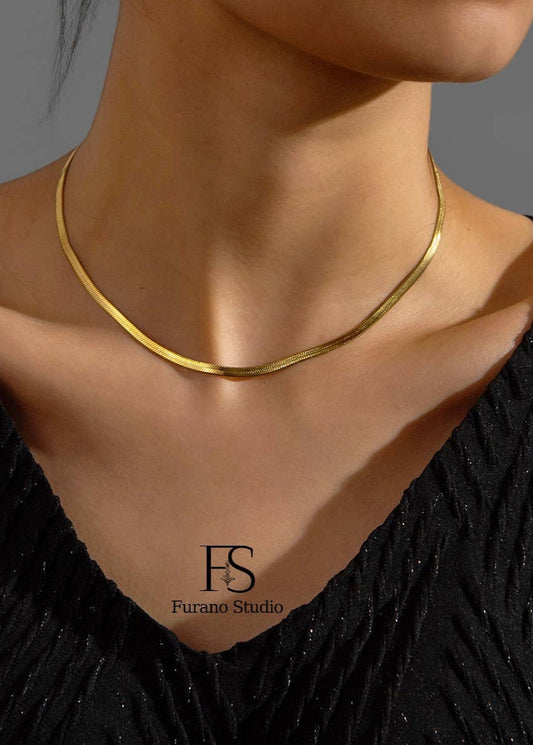 Gold necklace on a model with 'Furano Studio' logo.
