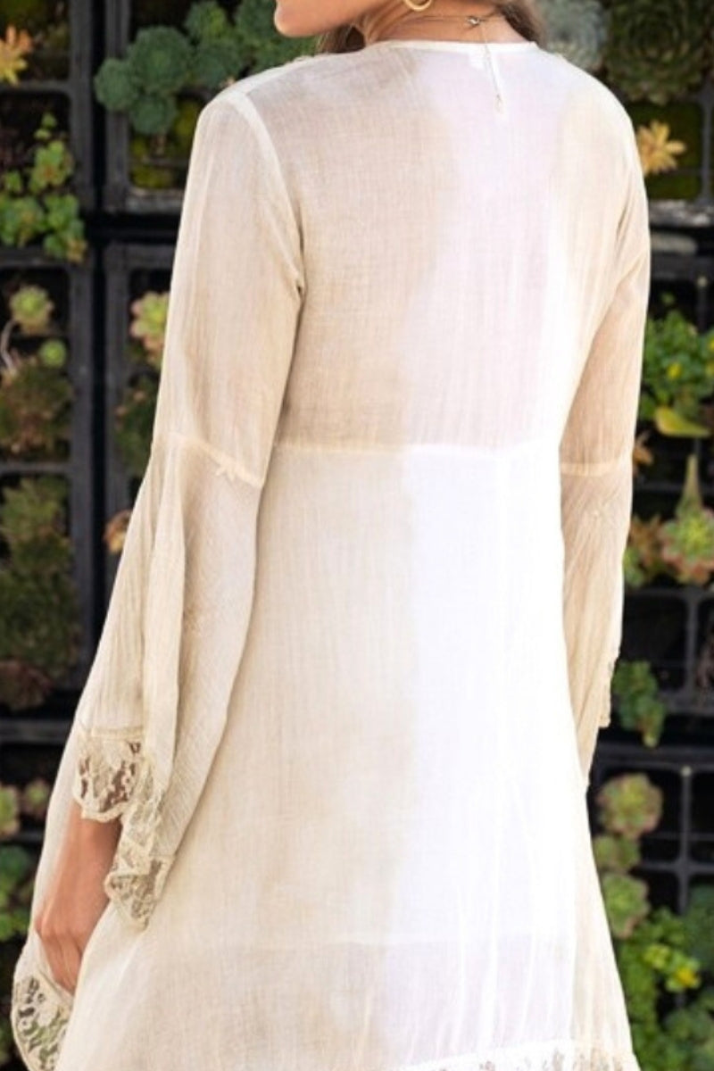 Person wearing a light-colored outfit with lace details in an outdoor setting
