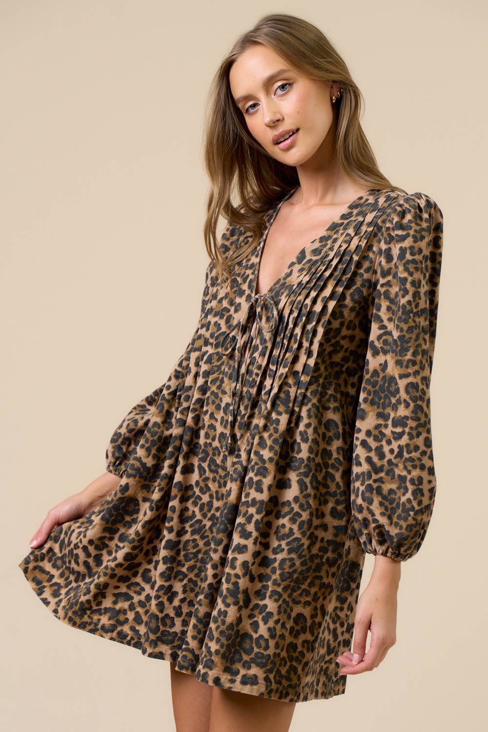 Woman wearing a leopard print romper against a beige background