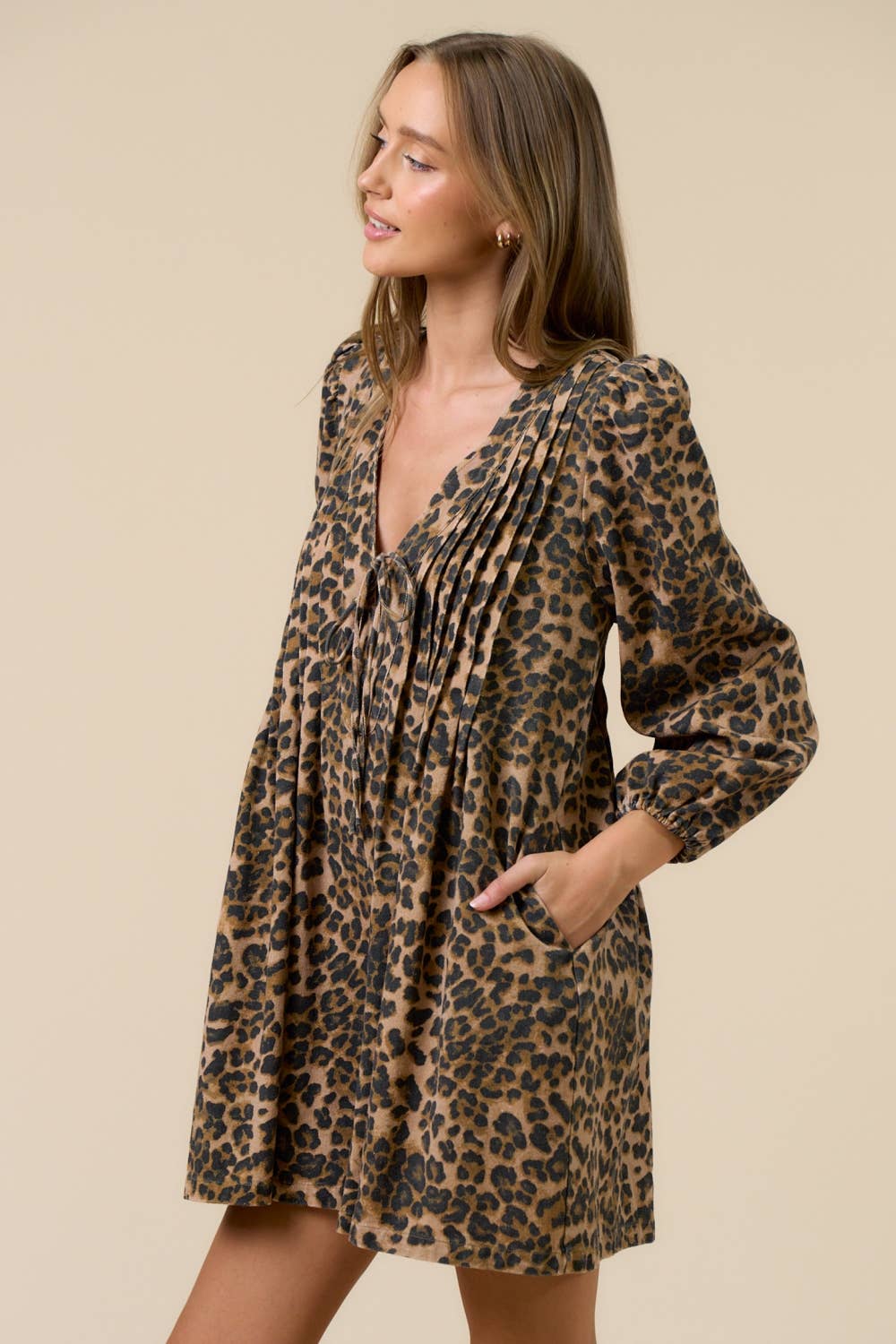 Woman wearing a leopard print romper against a beige background