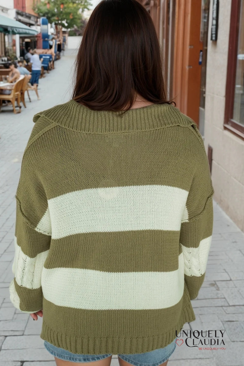 Person wearing a green and white striped sweater on a street.