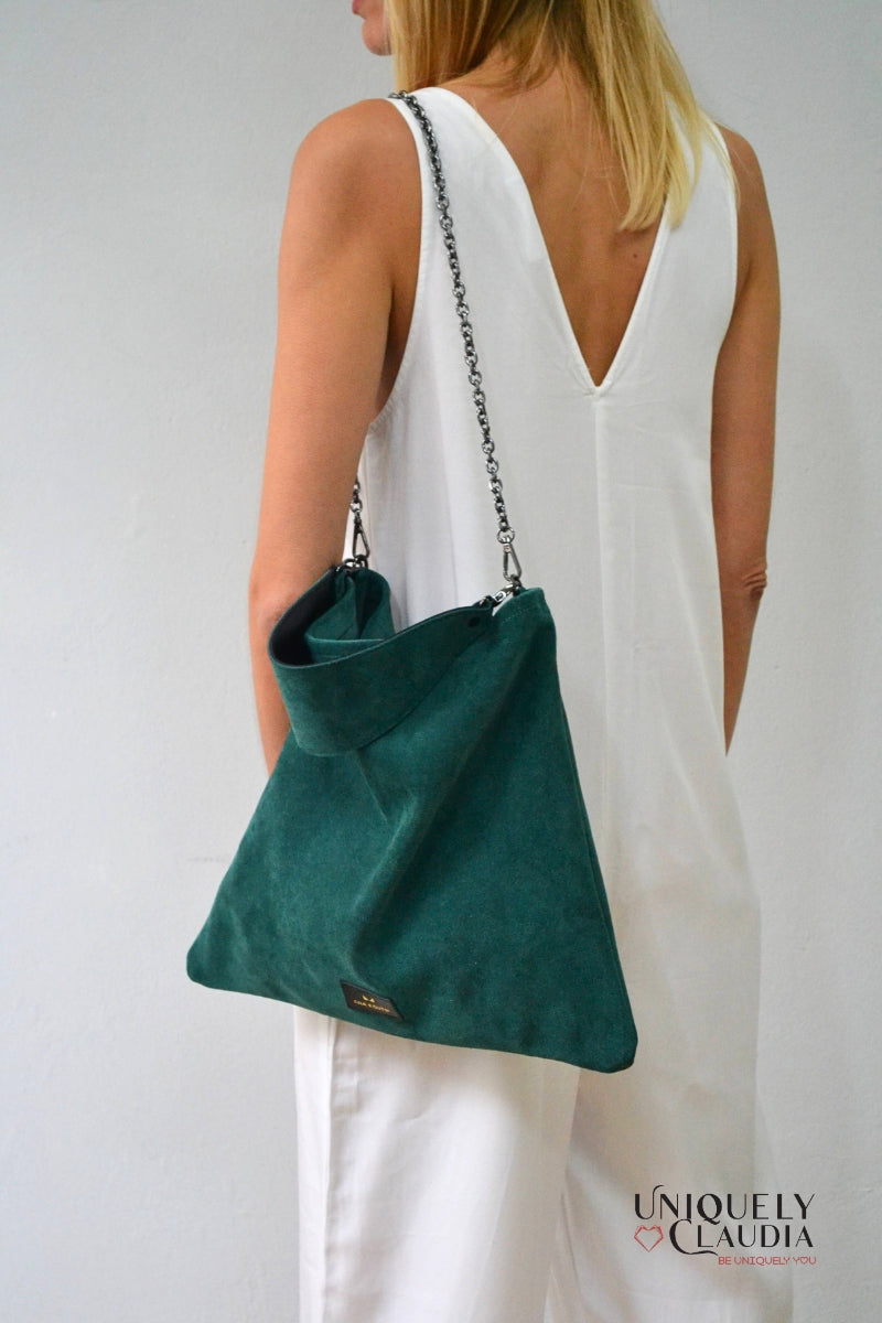 Person wearing a green bag over their shoulder against a plain background