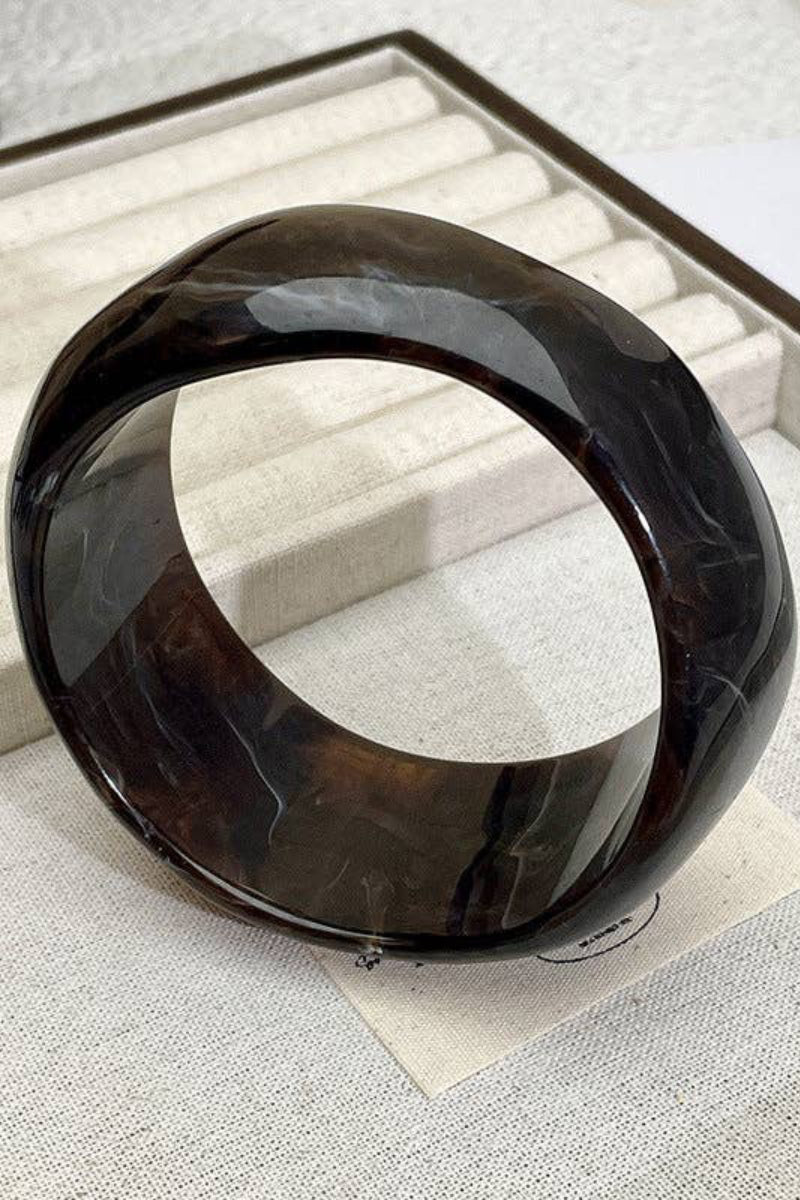 Black circular bangle on a textured surface