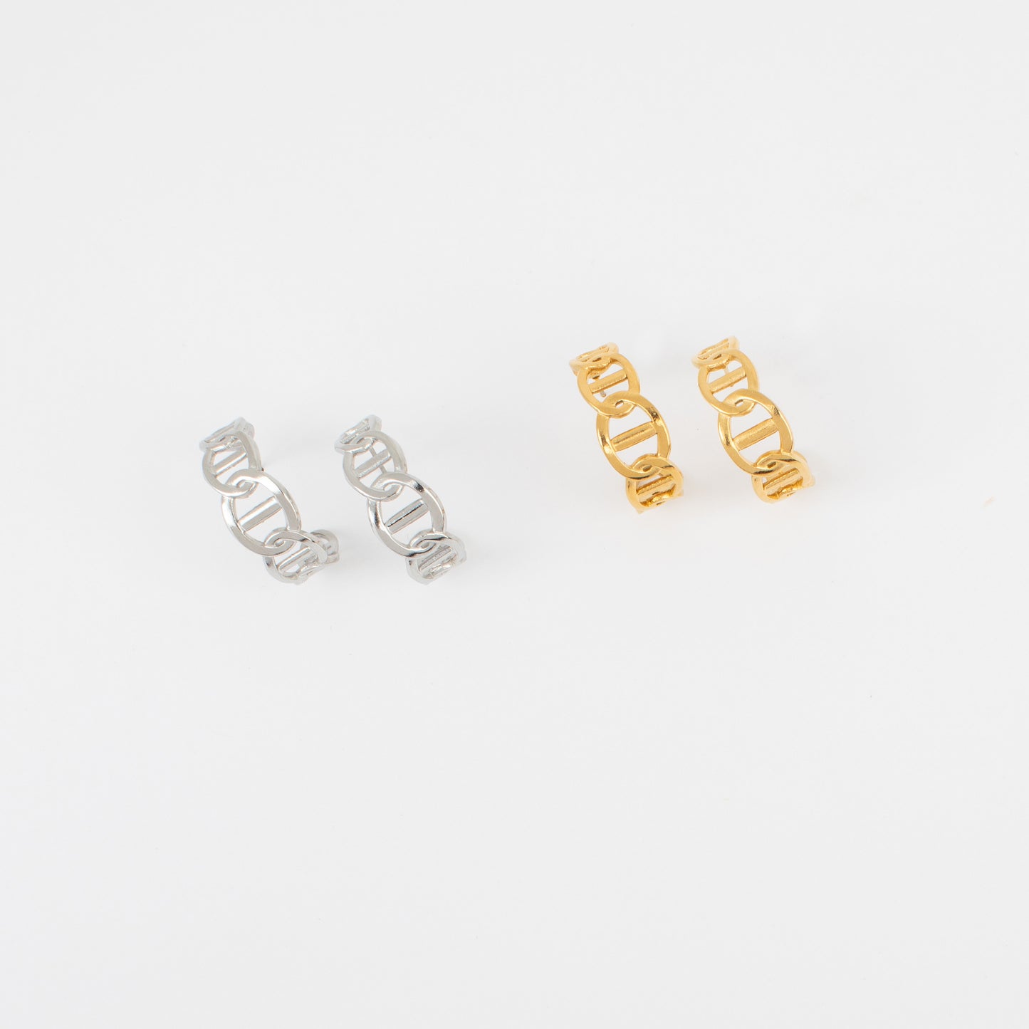 Two pairs of earrings, one silver and one gold, on a white background