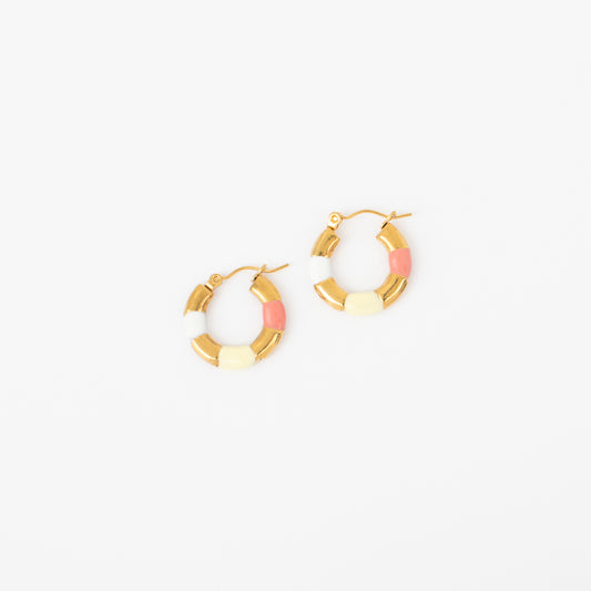 Pair of gold hoop earrings with pink and white accents on a white background