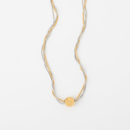 Gold necklace with a round pendant on a white background