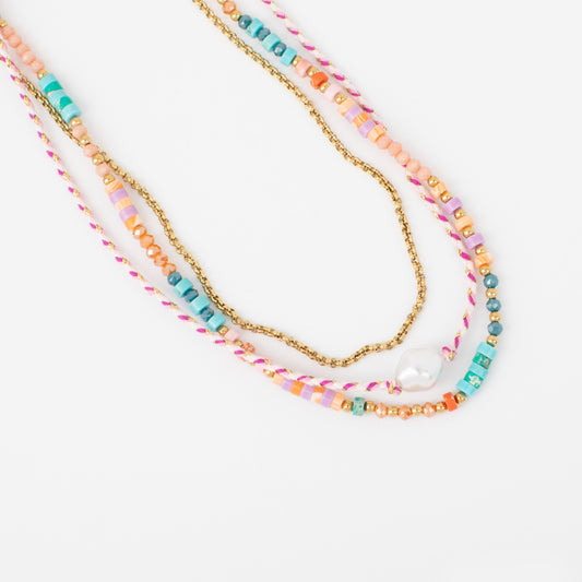 Colorful beaded necklaces with a gold chain on a white background