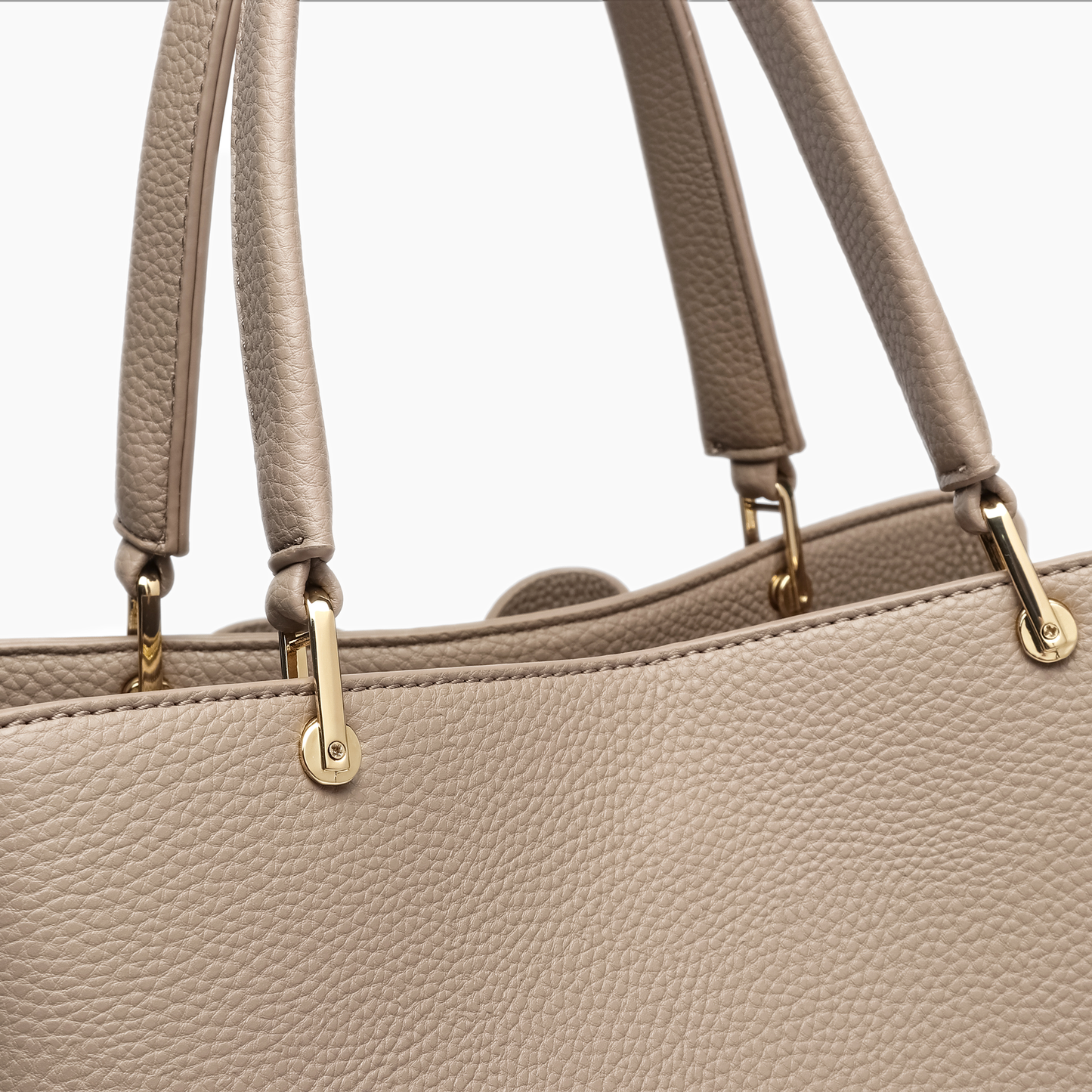 Close-up of a beige handbag with gold hardware