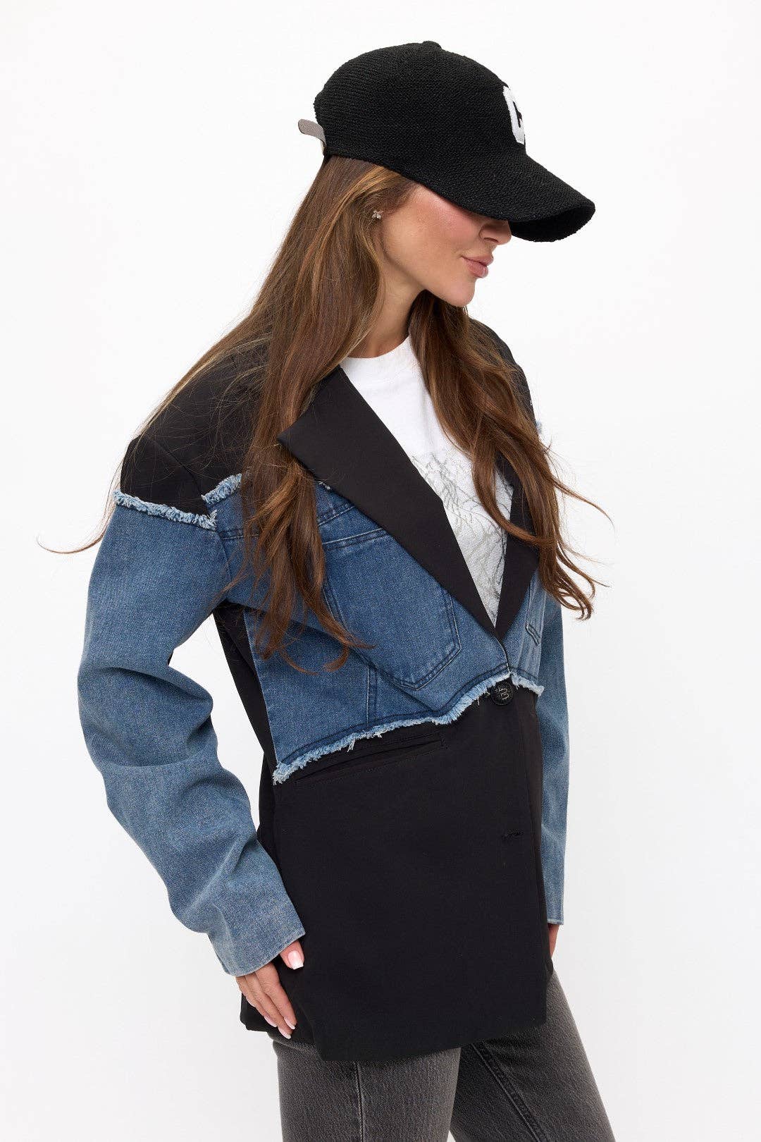 Woman wearing a black jacket with denim sleeves on a white background