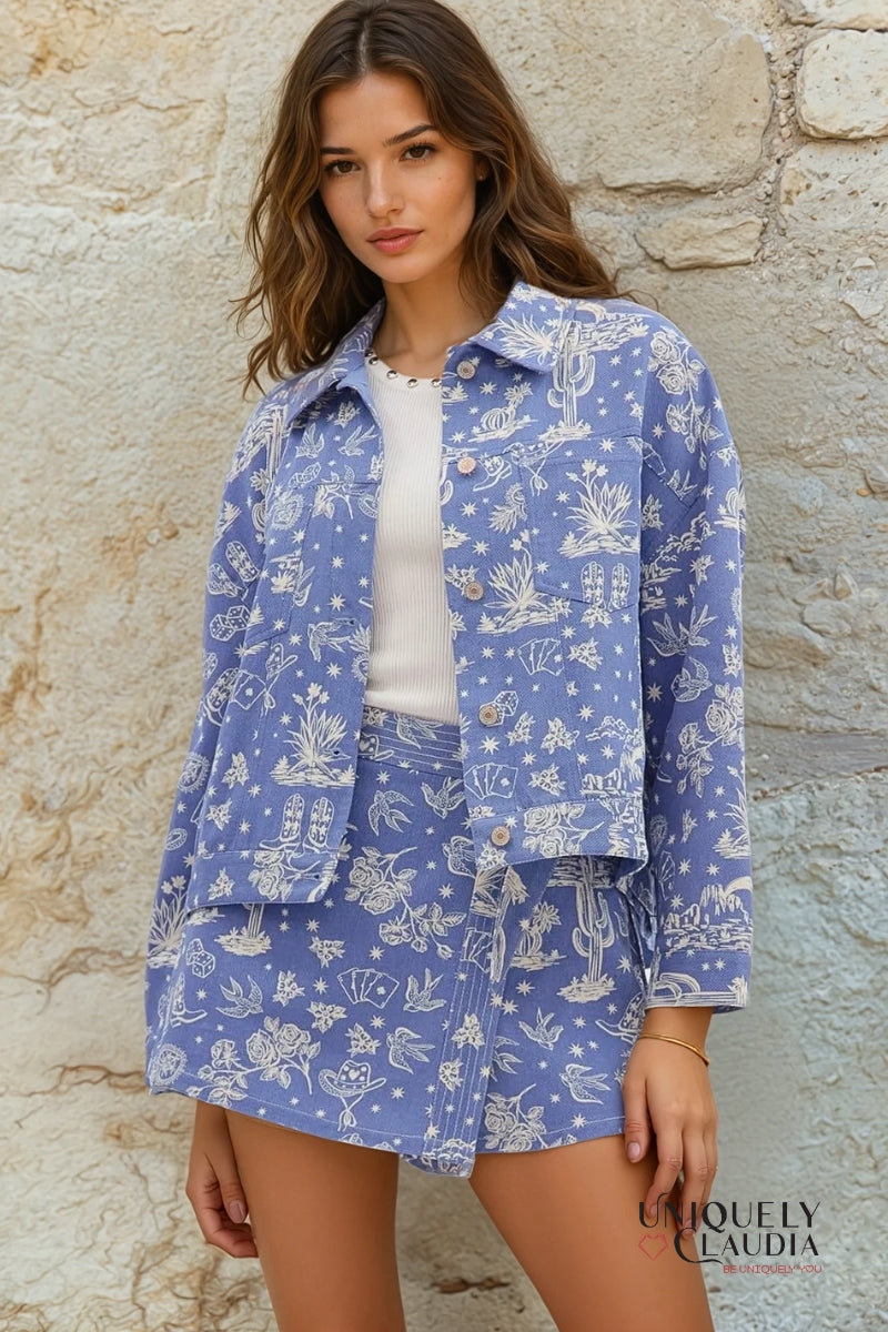 Woman wearing a blue floral patterned outfit against a stone wall.