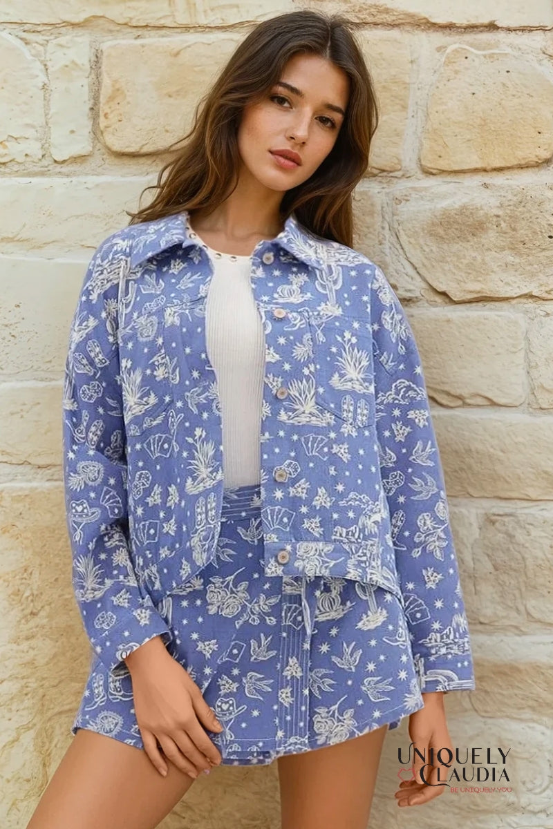 Woman wearing a blue floral patterned shirt and skirt against a stone wall.