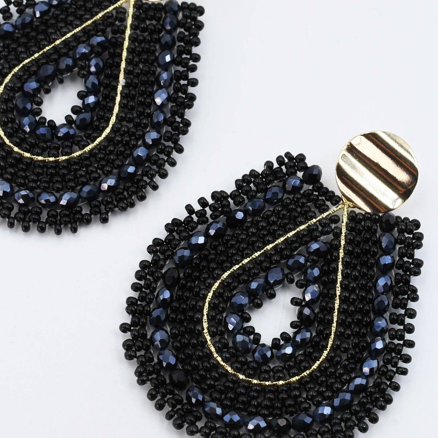 Black beaded earrings with gold accents on a white background
