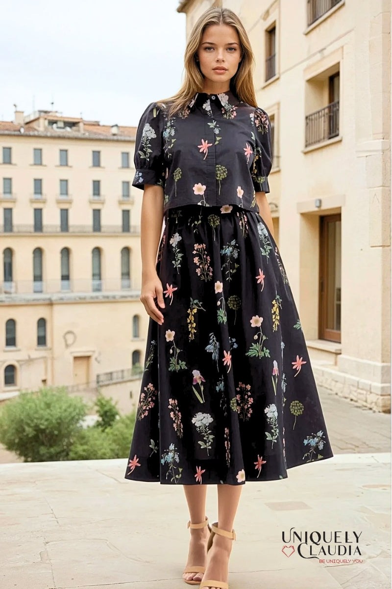 Woman wearing a black floral dress standing in front of a building