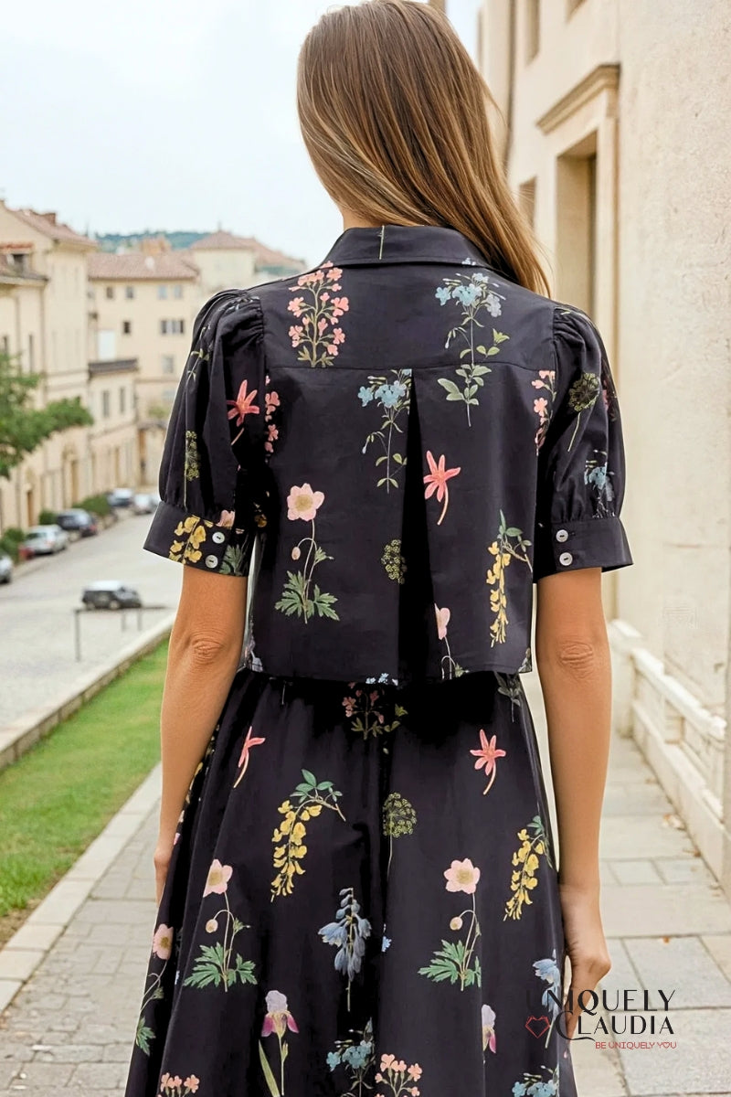 Woman wearing a black floral dress walking on a street.