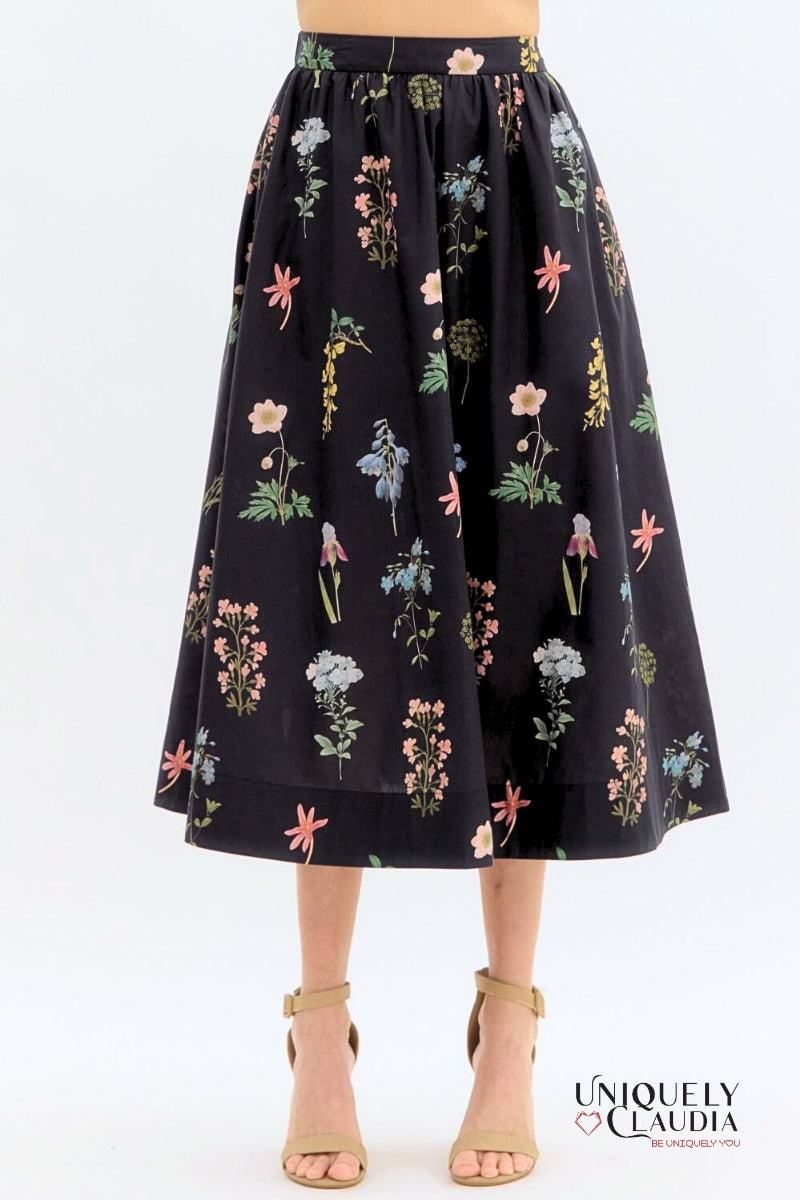 Black floral skirt worn by a person on a white background with 'Uniquely Claudia' branding.