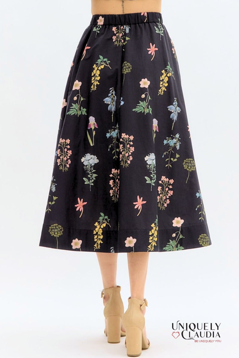 Floral-patterned black skirt on a white background with 'UNIQUELY CLAUDIA' branding.