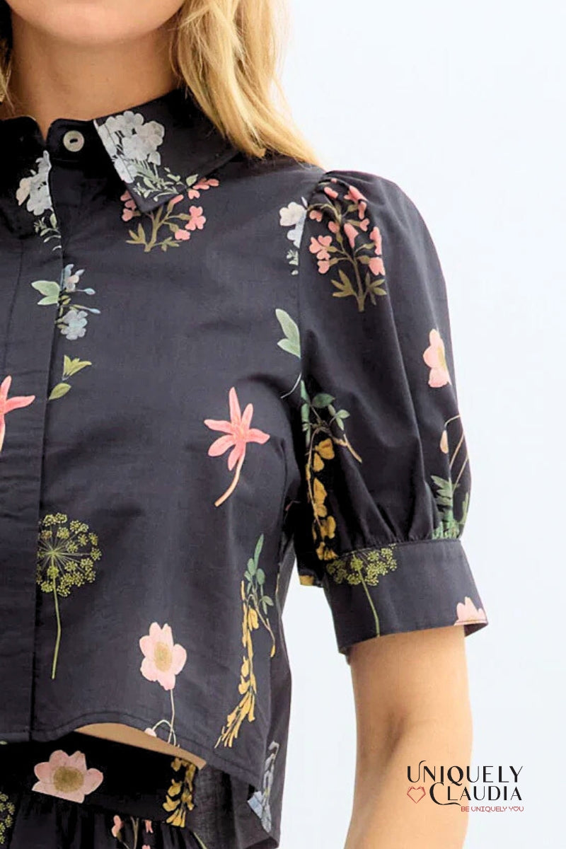 Navy blue shirt with floral patterns worn by a person on a white background, featuring 'Uniquely Claudia' branding.