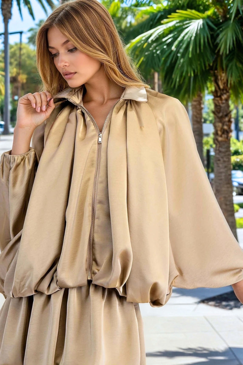 Woman wearing a beige dress with palm trees in the background