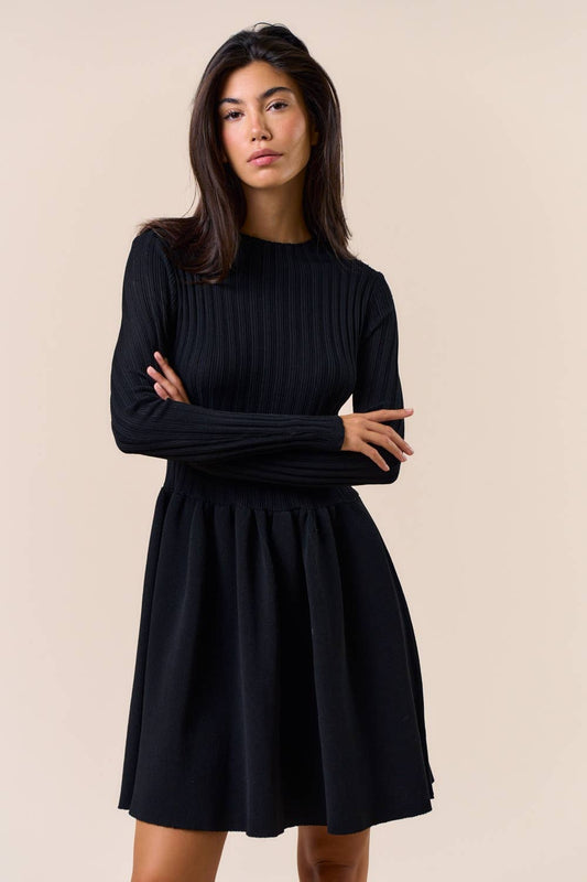 Woman wearing a black dress against a beige background