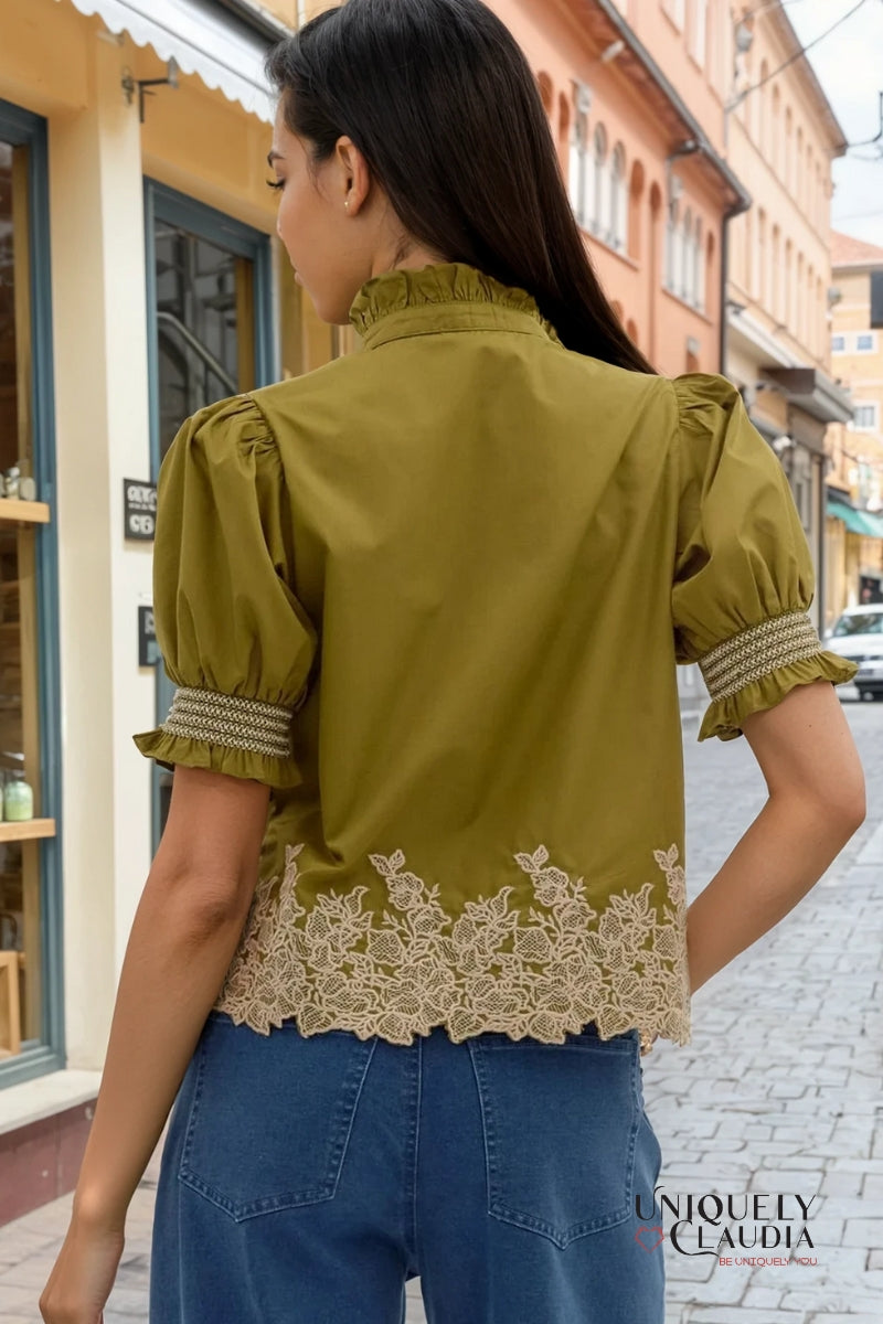 Woman wearing a green blouse with lace details in an urban setting