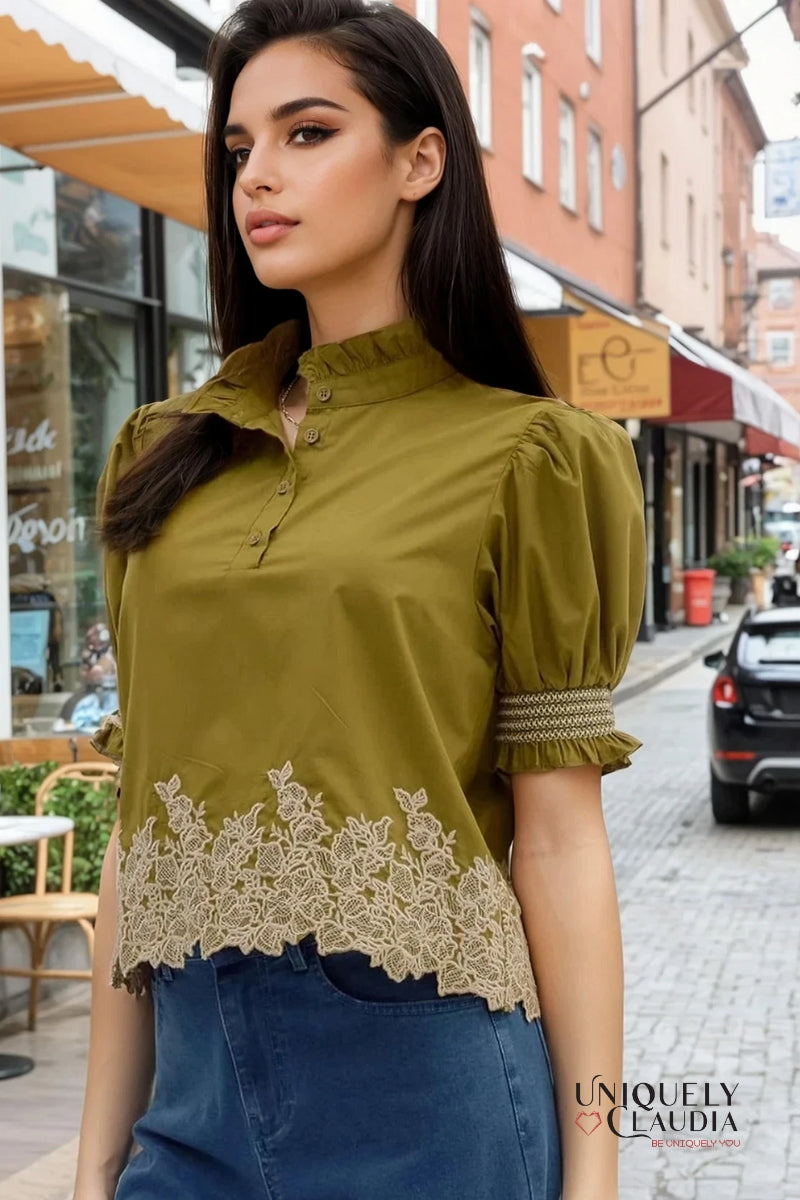 Woman wearing a green blouse with lace details on a city street