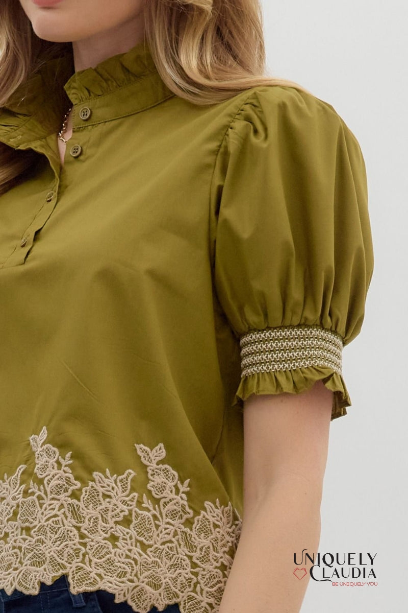 Green blouse with lace details and embroidered cuffs on a white background, featuring the brand 'Uniquely Claudia'.