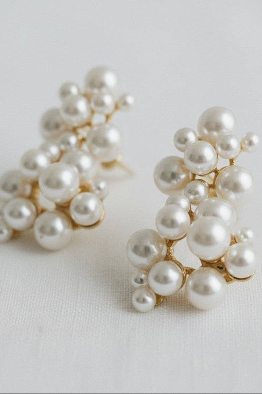 Pair of pearl earrings on a light gray background