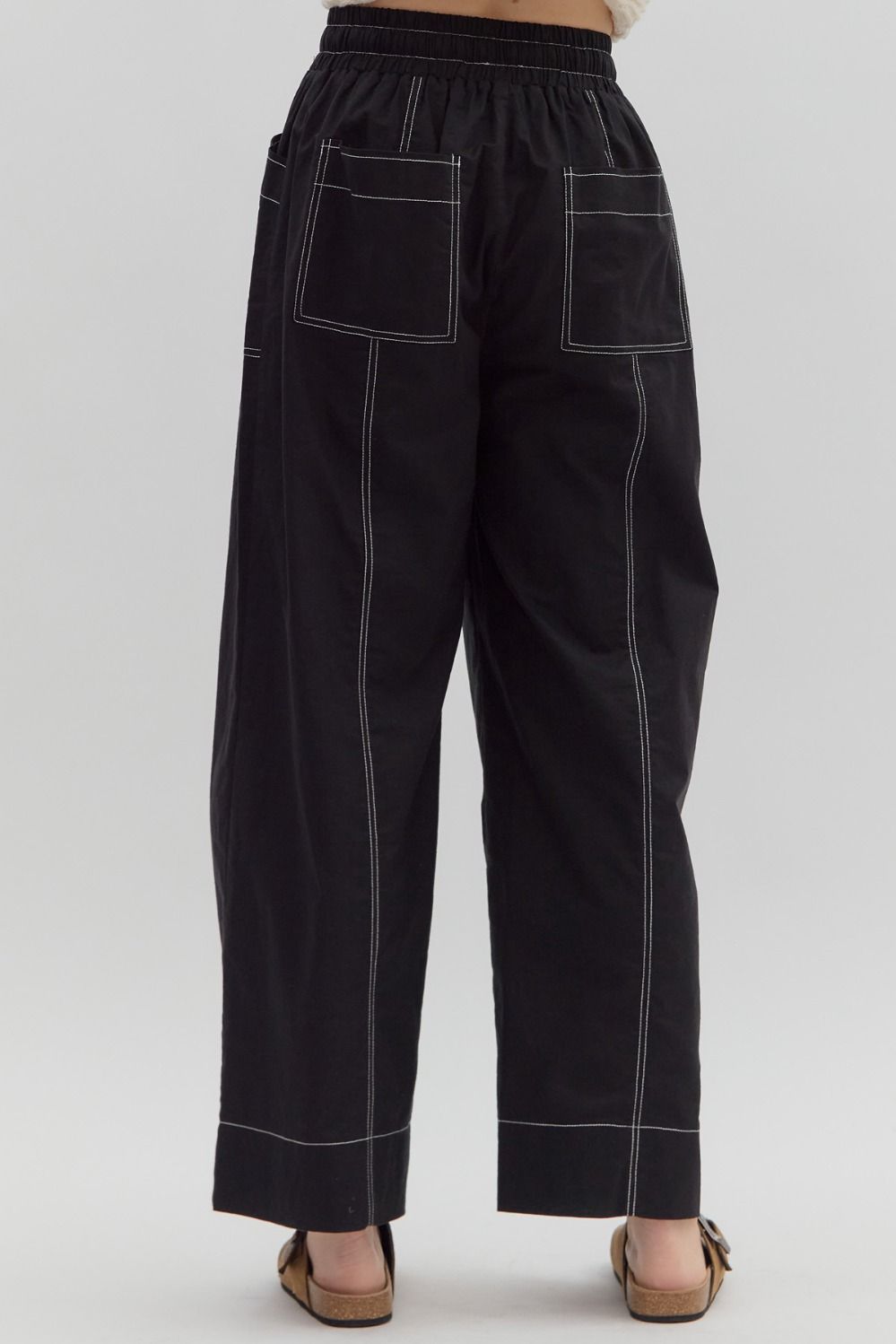Black pants with white stitching on a white background