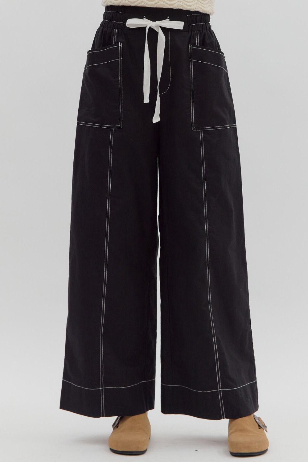 Black wide-leg pants with white drawstring on a white background