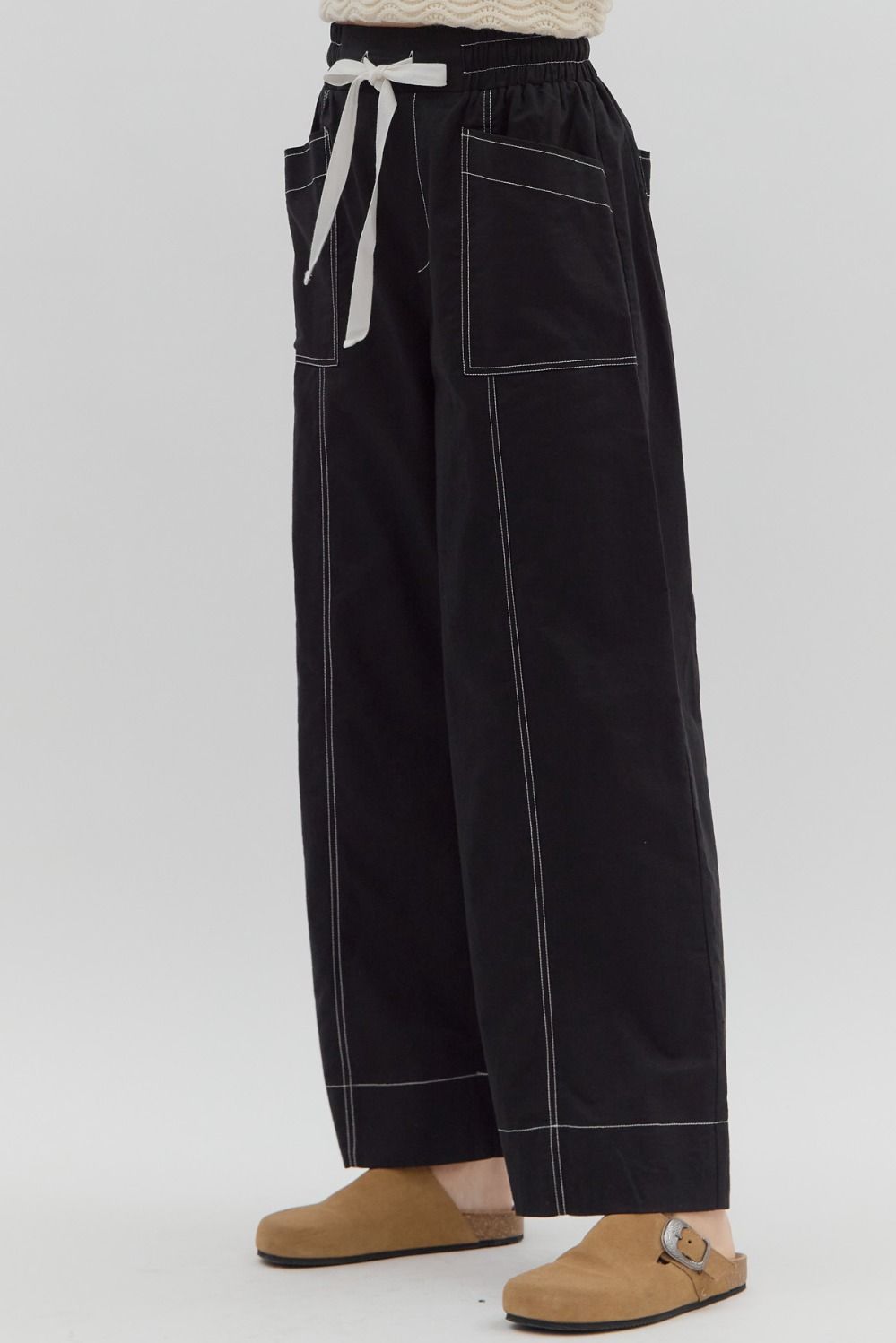 Black pants with white stitching on a white background