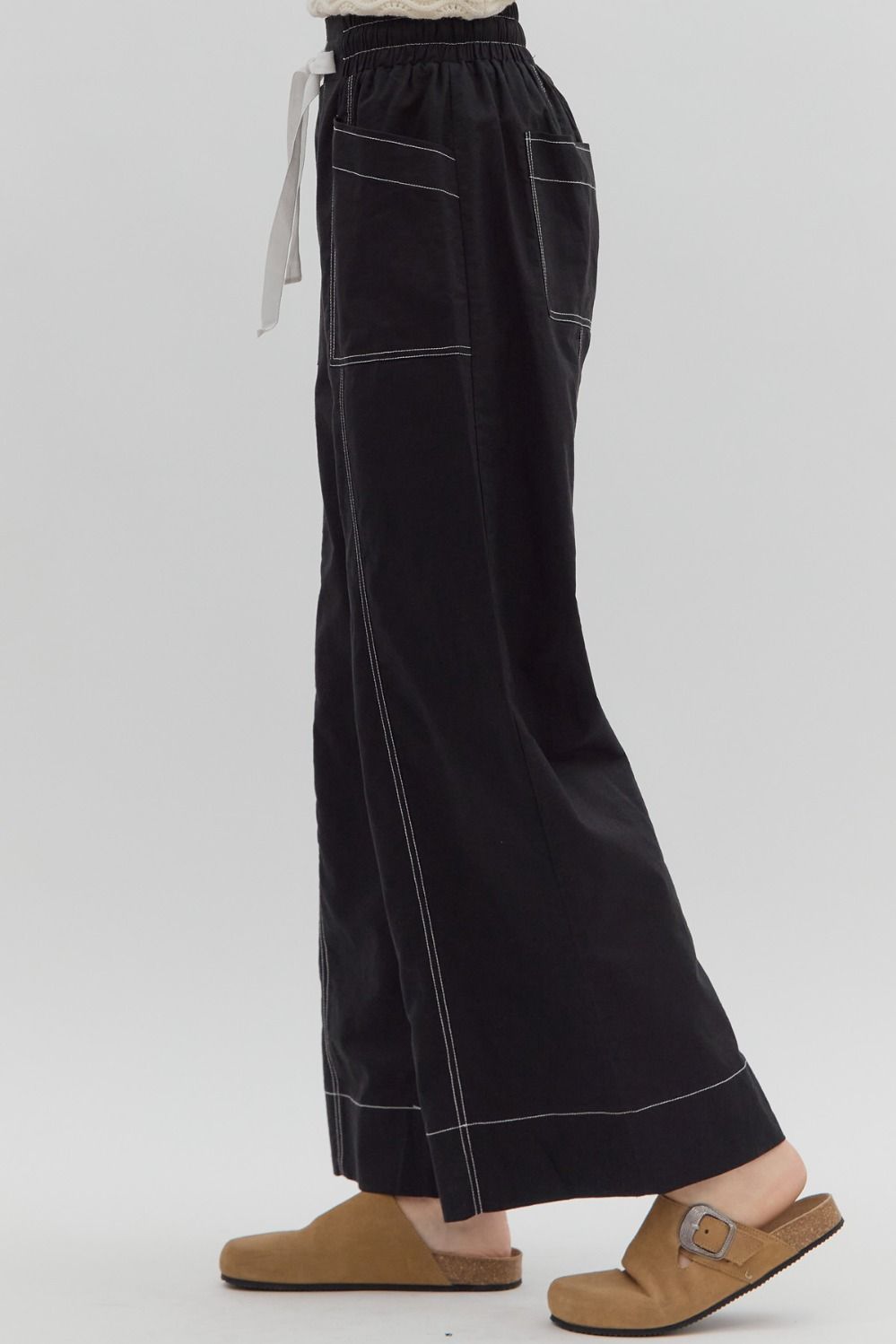 Black wide-leg pants worn by a person on a white background