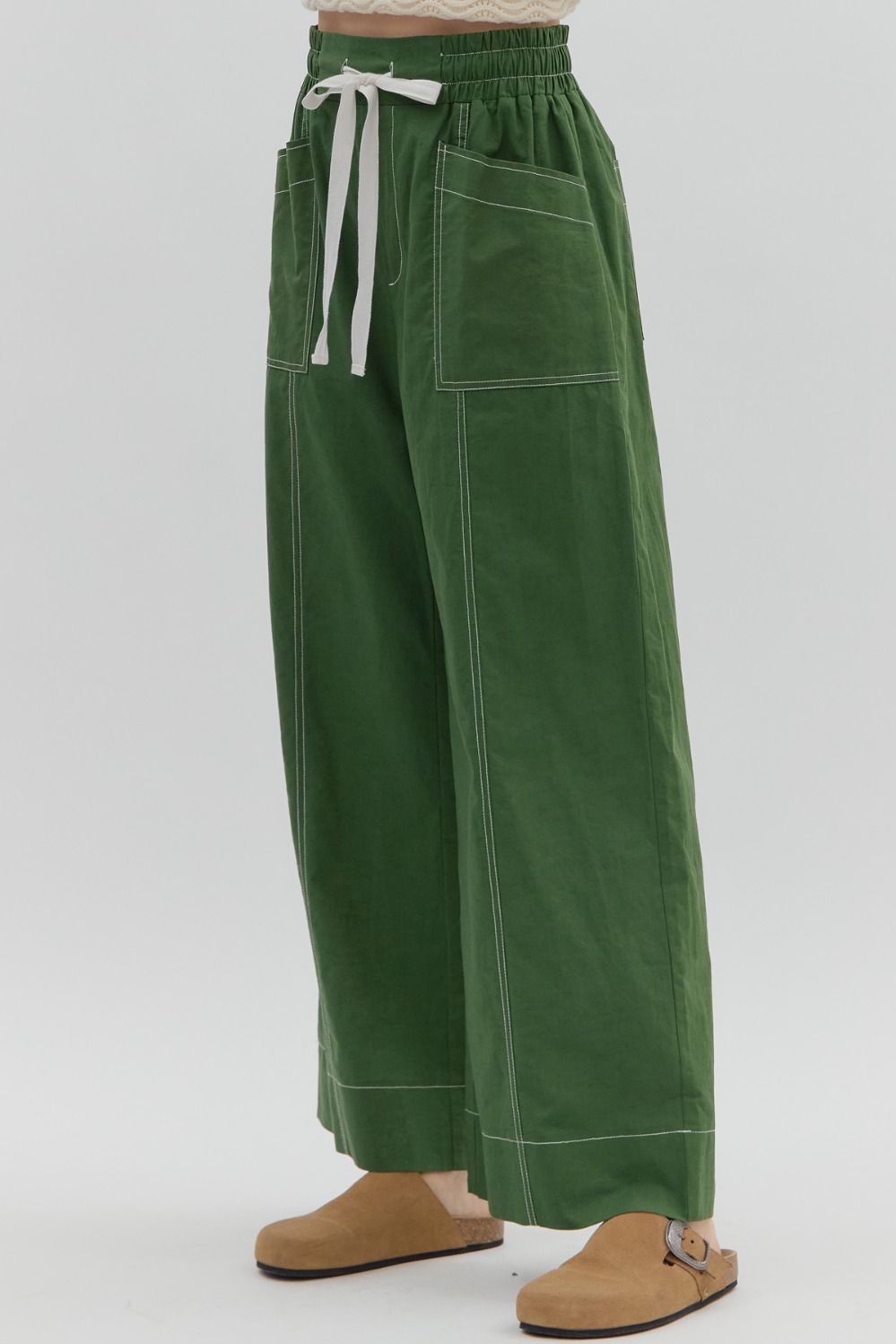 Green wide-leg pants with a white drawstring on a light gray background