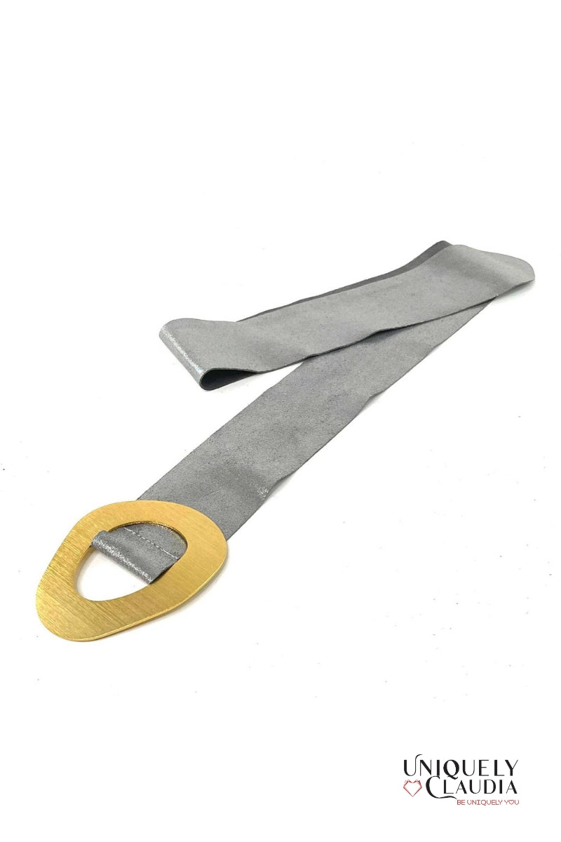 Gray belt with a gold buckle on a white background, branded 'Uniquely Claudia'.
