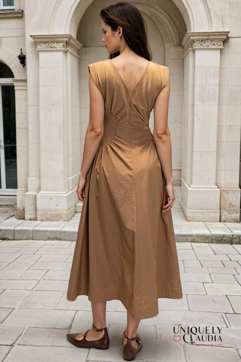 Woman wearing a brown dress standing in front of classical architecture
