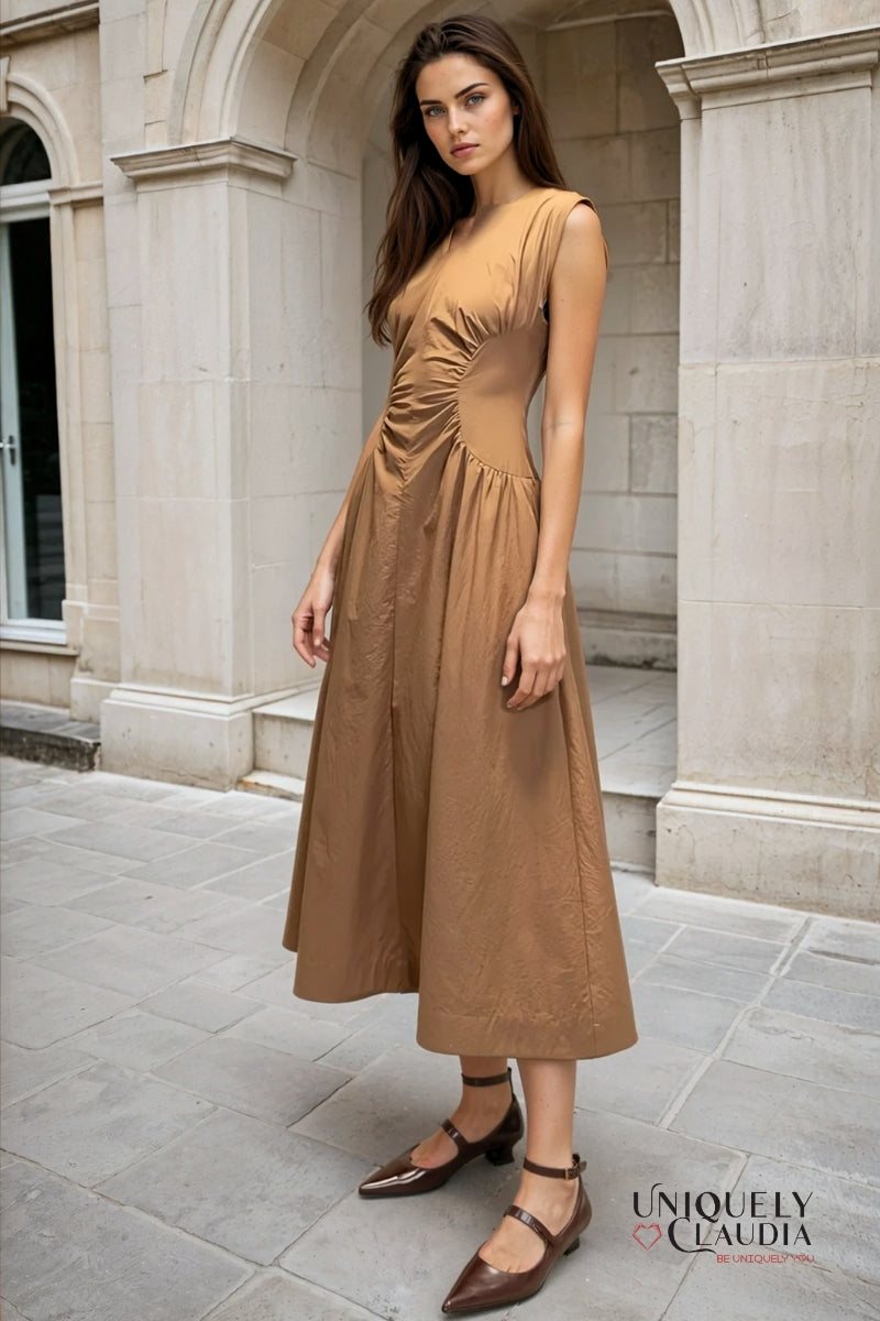 Woman in a brown dress standing in front of a stone building