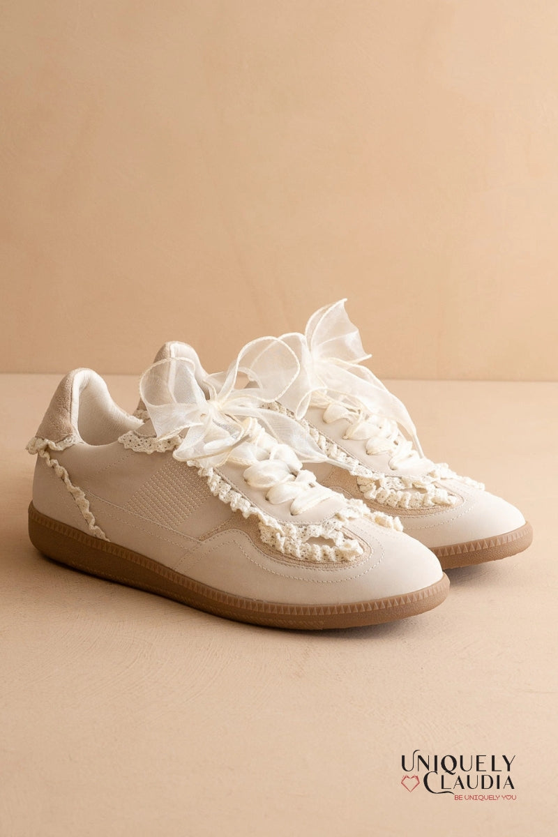 White sneakers with lace details on a beige background