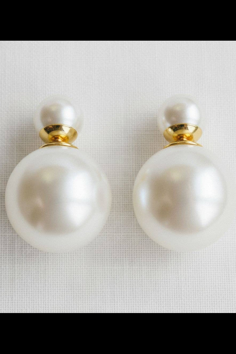 Pearl earrings with gold accents on a light gray background
