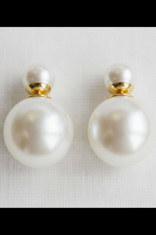 Pearl earrings with gold accents on a light gray background