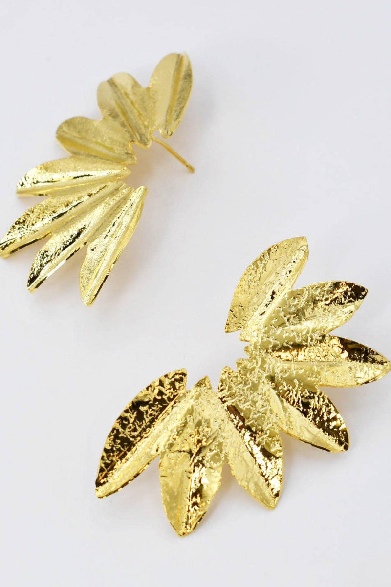 Gold leaf-shaped earrings on a light gray background