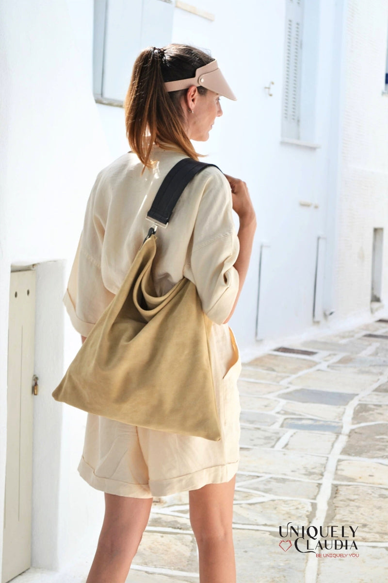 Woman carrying a beige tote bag on a sunlit street