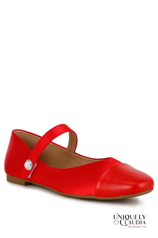Red flat shoe with a strap on a white background, featuring the brand 'Uniquely Claudia'.