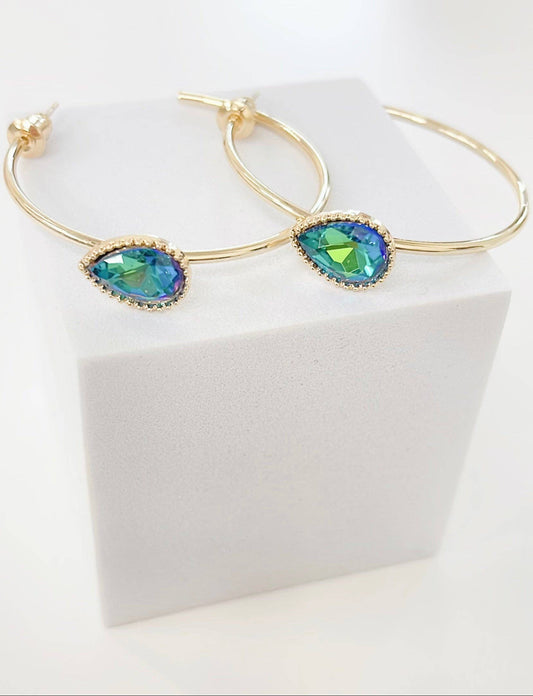 Gold bracelet with green gemstones on a white box