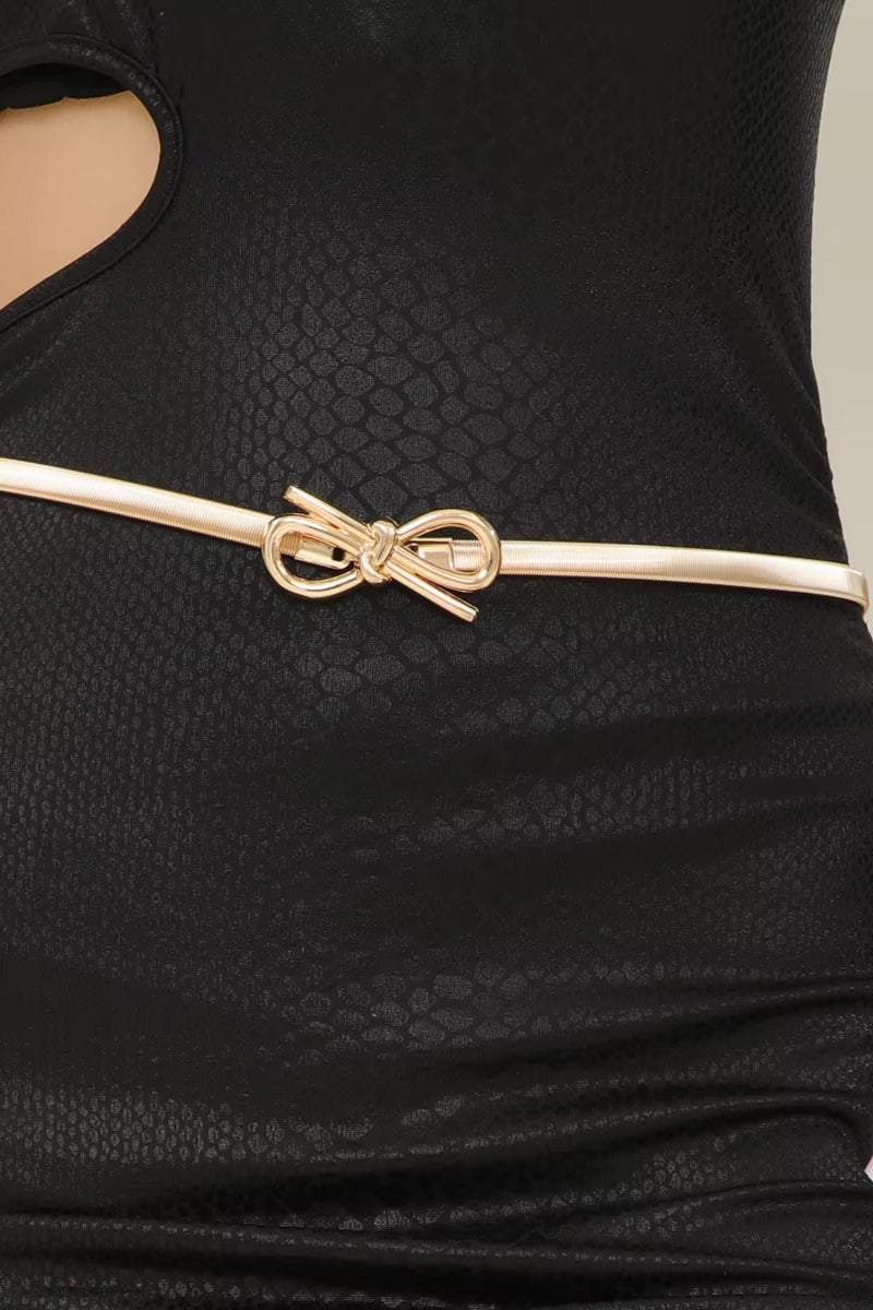 Black textured dress with a gold bow belt on a neutral background