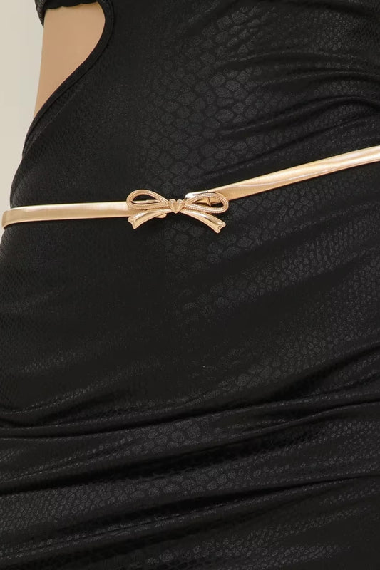 Black textured dress with a gold belt featuring a bow detail.