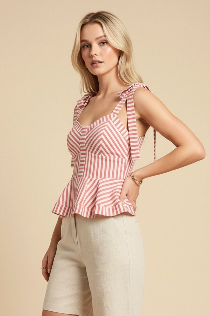 Woman wearing a red and white striped top with beige shorts on a beige background