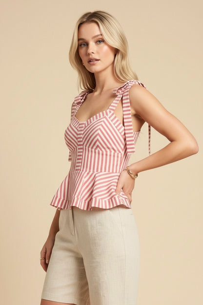 Woman wearing a red and white striped top with beige shorts on a beige background