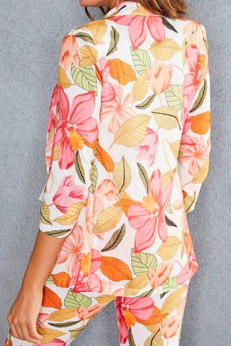 Floral patterned shirt with pink, orange, and green colors on a gray background