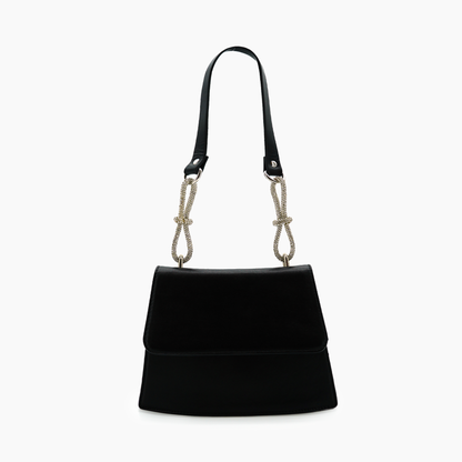 Black handbag with a unique strap design on a white background