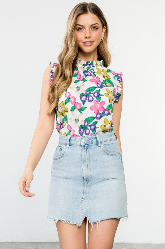 Woman wearing a floral top and denim skirt against a white background