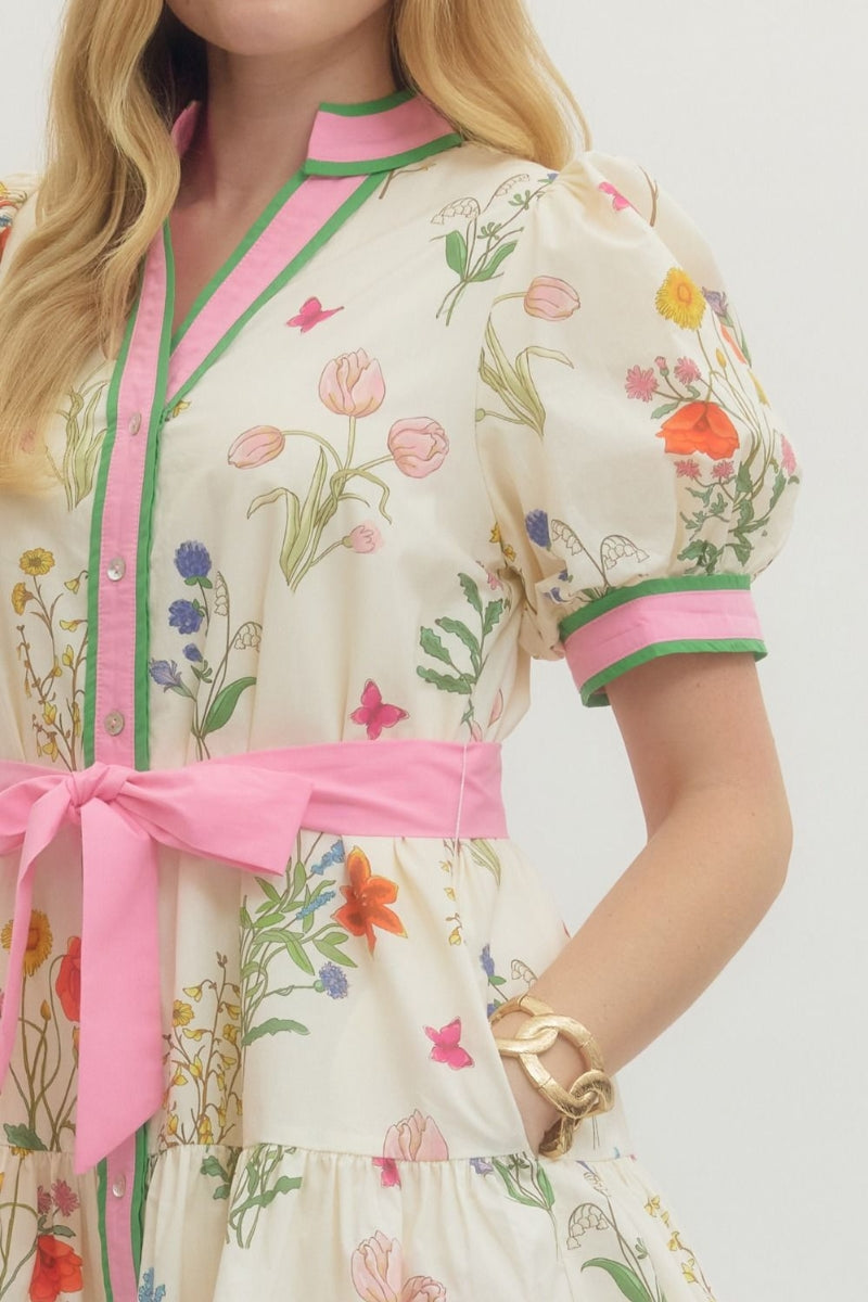 Woman wearing a floral dress with pink accents on a white background